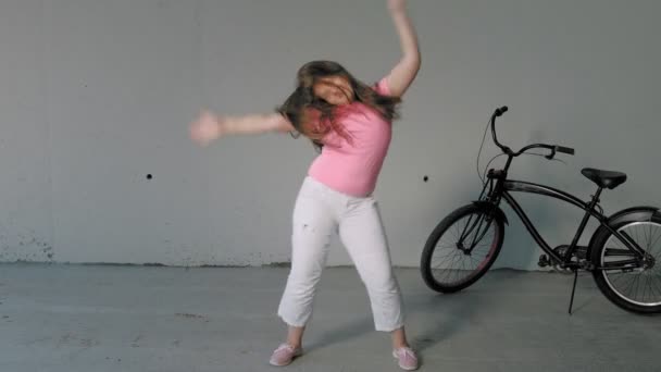 Chica adolescente bailando sobre un fondo gris. Baile callejero — Vídeos de Stock