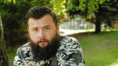 olgun sakallı adam açık havada duyguları tasvir eder. Yaz