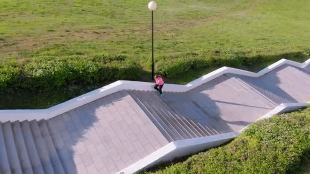 Une jeune fille monte les escaliers, fait du sport. Prise de vue aérienne — Video