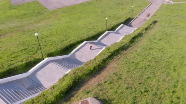 Une jeune fille monte les escaliers, fait du sport. Prise de vue aérienne — Video