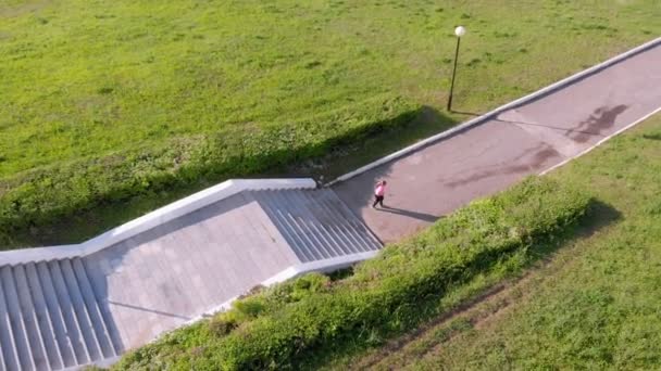 Une jeune fille monte les escaliers, fait du sport. Prise de vue aérienne 