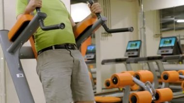 Şişman olgun adam bacak yapıyor spor salonunda yükselir. Fitness Sağlıklı yaşam tarzı