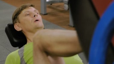 Spor salonunda simülatörde bacak presleri yapan aşırı kilolu bir adam. Fitness eğitimi. Sağlıklı yaşam tarzı kavramı