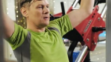 Kilolu adam spor salonundaüst bloğu paylaşıyor. Fitness. Sağlıklı yaşam tarzı.