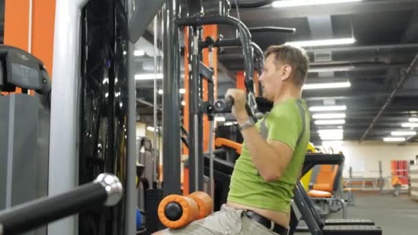 The overweight man shares the upper block in the gym. Fitness. Healthy lifestyle. — Stock Video