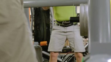 Kilolu adam bir halter için bir ağırlık diski ile squats ile çömelme yok. Fitness eğitimi. Sağlıklı yaşam tarzı kavramı