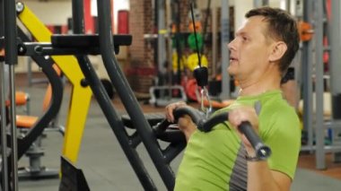 Kilolu adam spor salonundaüst bloğu paylaşıyor. Fitness. Sağlıklı yaşam tarzı.