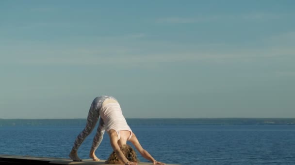 Молода жінка практикує йогу на відкритому повітрі влітку. Здоровий спосіб життя — стокове відео