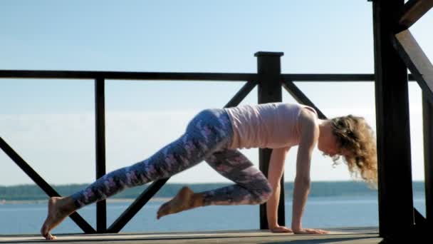 Jonge vrouw beoefenen van yoga buitenshuis in de zomer. Gezonde levensstijl — Stockvideo