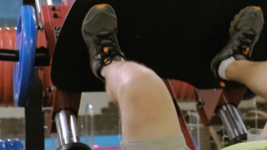 Spor salonunda simülatörde bacak presleri yapan aşırı kilolu bir adam. Fitness eğitimi. Sağlıklı yaşam tarzı kavramı