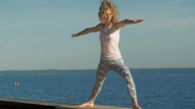Genç kadın yaz aylarında açık havada yoga yapıyor. Sağlıklı yaşam tarzı