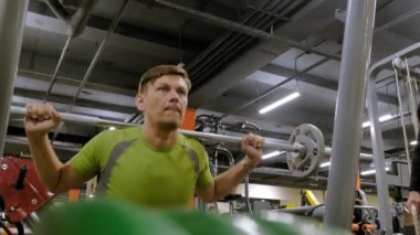 Kilolu adam bir halter için bir ağırlık diski ile squats ile çömelme yok. Fitness eğitimi. Sağlıklı yaşam tarzı kavramı