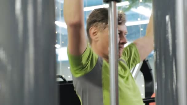 De overgewicht man deelt de bovenste blok in de sportschool. Fitness. Gezonde levensstijl. — Stockvideo