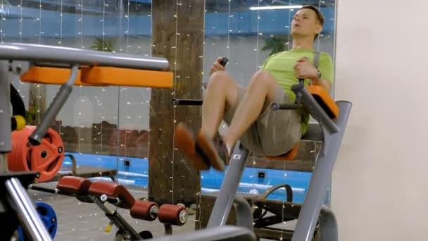 Vet volwassen man doen been stijgt in de sportschool. Fitness gezonde levensstijl — Stockvideo