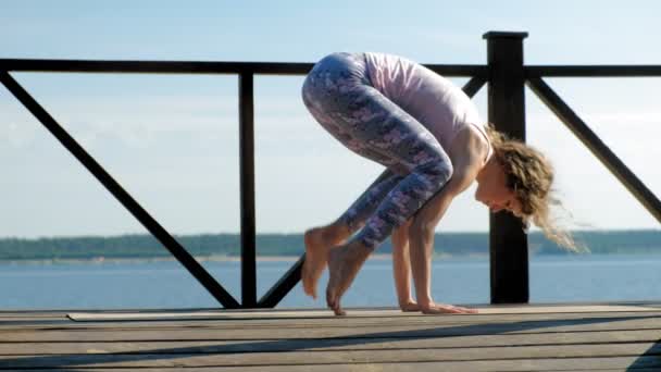 Jonge vrouw beoefenen van yoga buitenshuis in de zomer. Gezonde levensstijl — Stockvideo