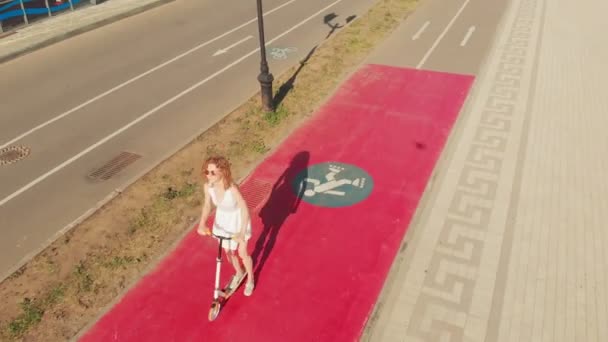 Femme en scooter à l'extérieur en été. Prise de vue aérienne — Video