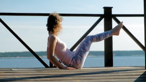 Junge Frau praktiziert im Sommer Yoga im Freien. Gesunder Lebensstil — Stockvideo