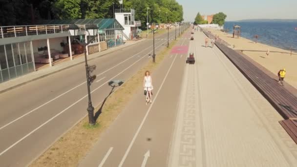 Mulher montando uma scooter ao ar livre no verão. Tiro aéreo — Vídeo de Stock