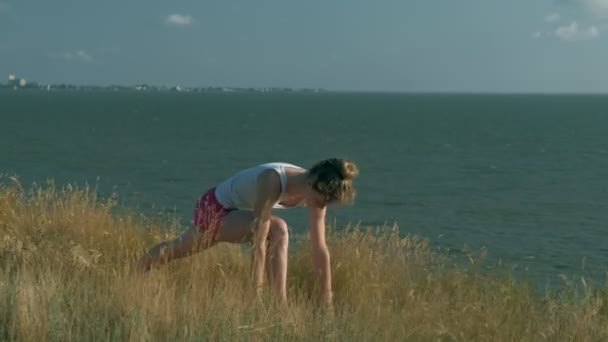 Jeune femme faisant du sport à l'extérieur, yoga — Video