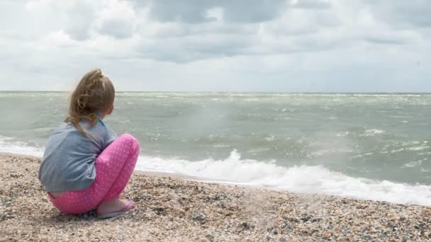 Kleines Mädchen am Meeresstrand sammelt Muscheln. Sommer — Stockvideo