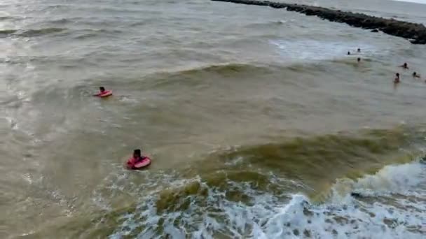 Az emberek a Gumigyűrűk úszni a hullámok a tengerben. Légifelvételek — Stock videók