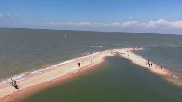 Dolzhanskaya, Rússia - 10 de julho de 2019: as pessoas caminham sobre um espeto de areia que vai para o mar. Filmagem de vídeo aéreo — Vídeo de Stock