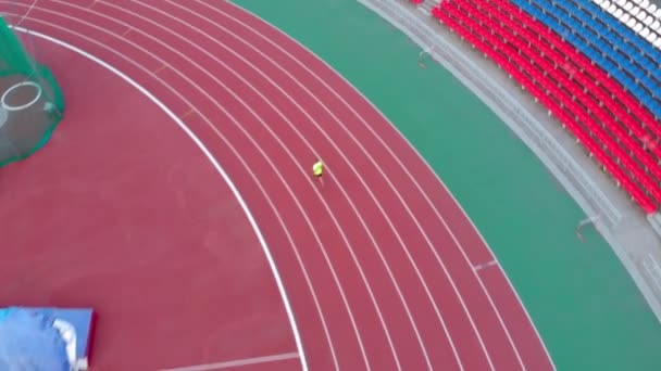 Un hombre corre en una cinta en el estadio. Hora de verano — Vídeo de stock