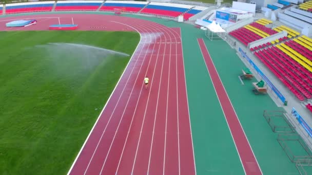 Een man loopt op een loopband in het stadion. Zomertijd — Stockvideo