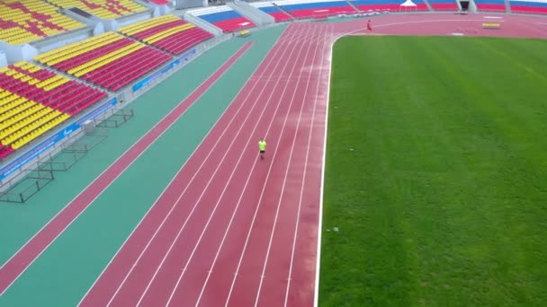 A man runs on a treadmill at the stadium. Summer time — Stock Video