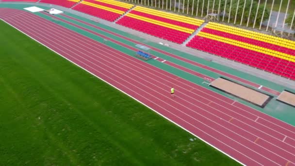 Un hombre corre en una cinta en el estadio. Hora de verano — Vídeo de stock