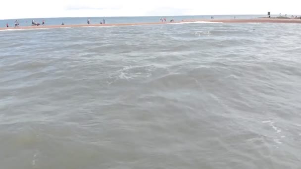 Должанская, Россия - 10 июля 2019 года: люди ходят по песчаной косе, которая уходит в море. Аэросъемка — стоковое видео