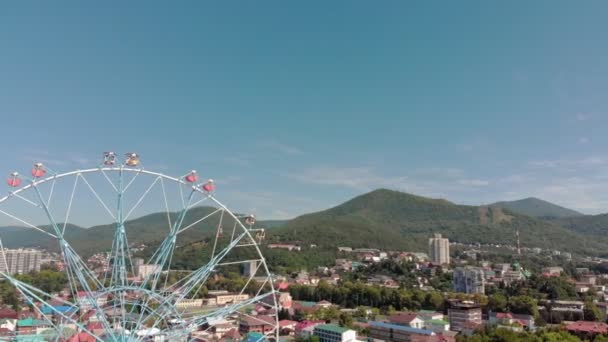 Rueda de la fortuna en la orilla del mar. Disparo aéreo — Vídeos de Stock