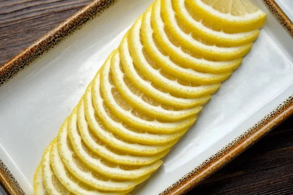 Limão fatiado fino em um fundo de madeira marrom. menu restaurante — Fotografia de Stock