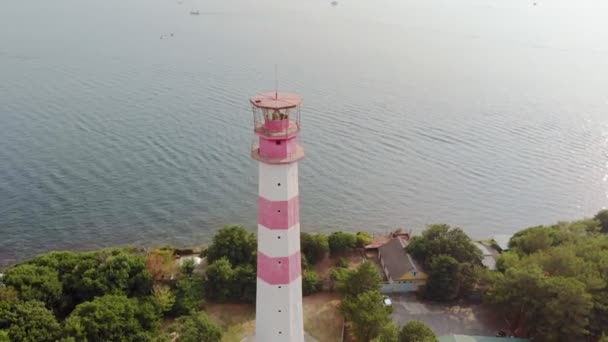 Volando alrededor del faro en la orilla del mar. Disparo aéreo — Vídeos de Stock