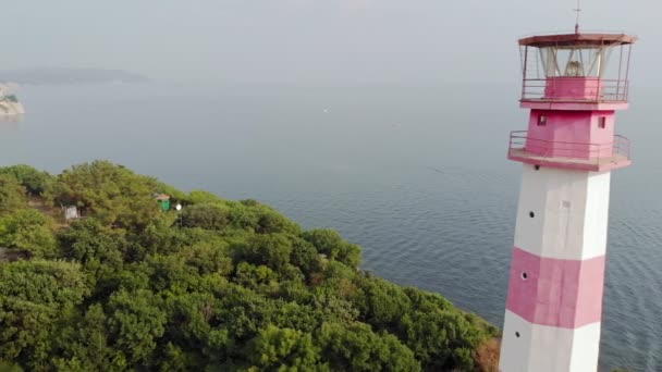 Volando alrededor del faro en la orilla del mar. Disparo aéreo — Vídeo de stock