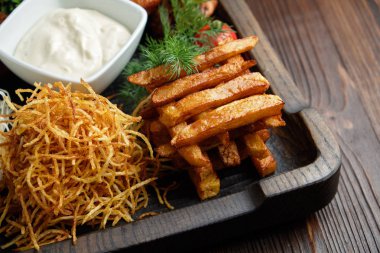 Koyu ahşap arka plan üzerinde ahşap siyah bir plaka üzerinde sıcak meze. Restoran menüsü