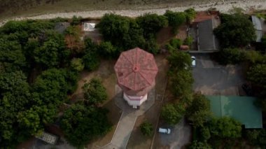 Deniz kıyısındaki deniz fenerinin etrafında uçuyor. Havadan çekim