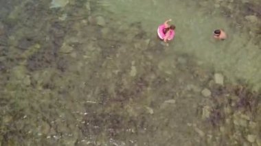 İki genç mavi denizde yüzer. Havadan çekim