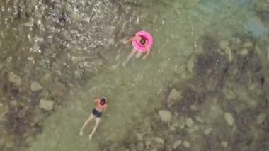 İki genç mavi denizde yüzer. Havadan çekim