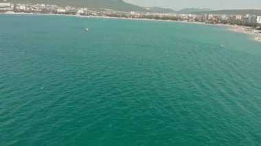 Yelkenli beyaz bir yat yazın mavi denizde yüzer. Havadan çekim
