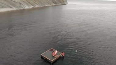 Neşeli çocuklar bir saldan denize atlıyorlar. Havadan çekim