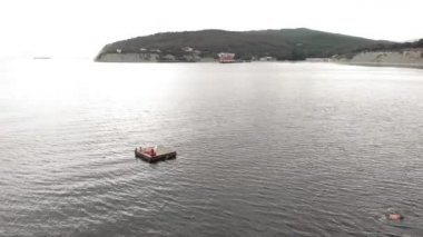 Neşeli çocuklar bir saldan denize atlıyorlar. Havadan çekim