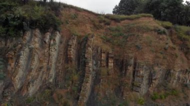 Şafakta denizde kayalık bir sahilden uçun. Havadan çekim