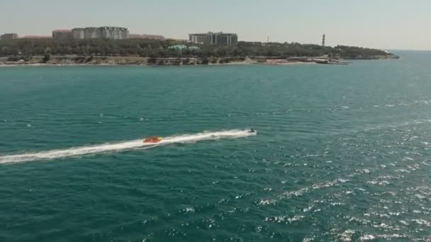 Un yate blanco con una vela flota en el mar azul en verano. Disparo aéreo — Vídeos de Stock