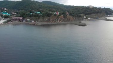 Şafakta denizde kayalık bir sahilden uçun. Havadan çekim