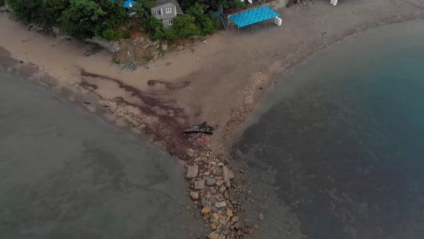 Vlucht over een rotsachtig strand in de zee bij zonsopgang. Luchtfoto — Stockvideo