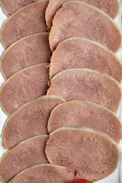 Beef tongue sliced in thin slices on a plate on a brown rustic background. restaurant menu — Stock Photo, Image