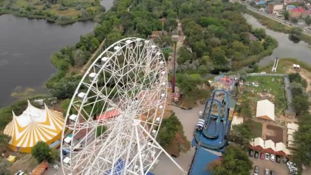 Amusement park by the sea. View of the ferris wheel and the water park with a drone. Shooting from a height — Stock Video
