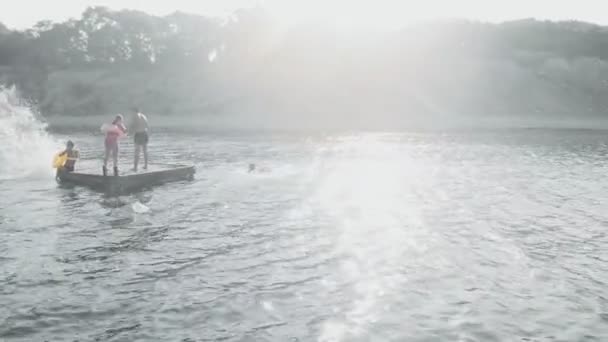 Cheerful teenagers are jumping into the sea. Aerial shot — Stock Video