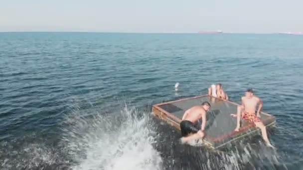 Adolescentes alegres están saltando al mar. Disparo aéreo — Vídeos de Stock
